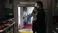 Semuanya dimulai di bandara, di mana pekerja berjas putih seluruh tubuh memimpin atlet, pelatih mereka, dan lainnya melalui prosedur masuk, termasuk tes COVID-19 harian pertama. AP/Kiichiro Sato