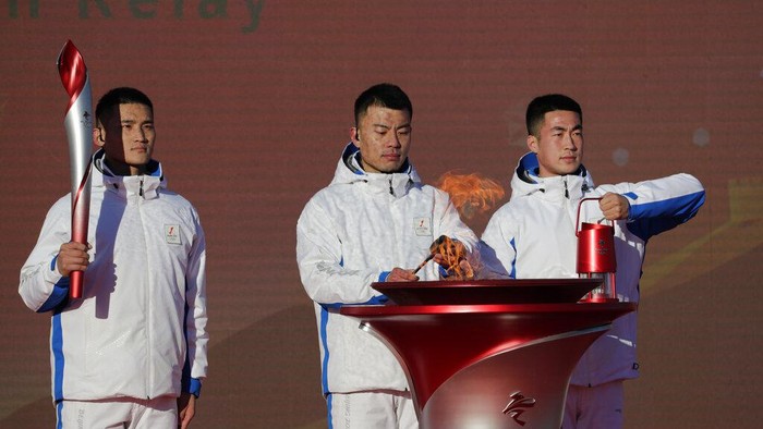 First Torch bearer Luo Zhihuan holds up the torch at the start of the torch relay for the 2022 Winter Olympics at the Olympic Forest Park in Beijing on Wednesday, Feb. 2, 2022. (AP Photo/Sam McNeil)