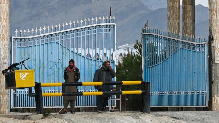 Taliban fighters stand guard at the main gate of Laghman University in Mihtarlam, Laghman province on February 2, 2022. (Photo by Mohd RASFAN / AFP)