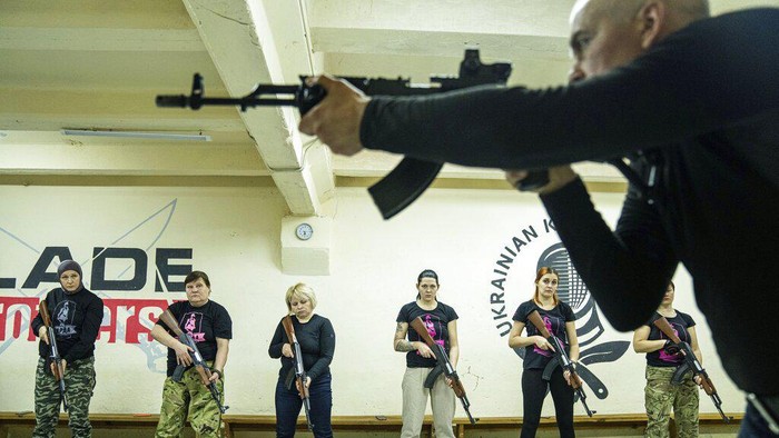 An instructor shows how to use weapons to a group of women during training in Kharkiv, Ukraine, Sunday, Jan. 30, 2022. Some people in Ukraine's second-largest city are preparing to fight back if Russia invades. Kharkiv is just 40 kilometers (25 miles) from some of the tens of thousands of Russian troops massed at the border. (AP Photo/Evgeniy Maloletka)
