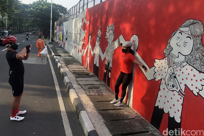Semangat Kota di Dinding Kata Warga berfoto di depan mural yang berisi pesan semangat untuk menjalani masa pandemi di Jl Tentara Pelajar, Jakarta, Selasa (1/2/2022).
