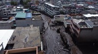Gelombang lumpur, setinggi sekitar 3 meter (10 kaki), membawa kendaraan, sepeda motor, tempat sampah dan puing-puing lainnya di bawah hujan lebat di lingkungan La Gasca dan La Comuna di bawah lereng gunung Ruco Pinchincha.