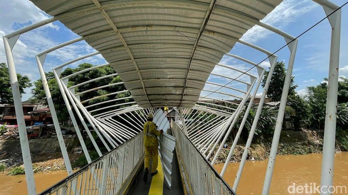 Aksi Pasukan Kuning Saat Ganti Atap JPO Jayakarta di Manggarai Petugas Dinas Bina Marga DKI Jakarta memperbaiki JPO Jayakarta di Manggarai. Atap JPO yang sebelumnya berbahan plastik diganti dengan atap berbahan alumunium.