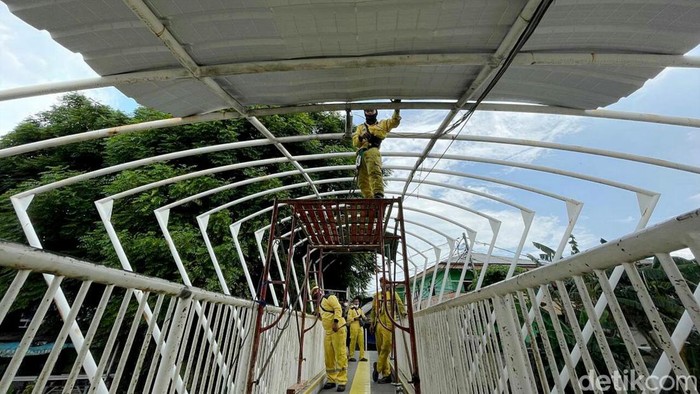 Aksi Pasukan Kuning Saat Ganti Atap JPO Jayakarta di Manggarai Petugas Dinas Bina Marga DKI Jakarta memperbaiki JPO Jayakarta di Manggarai. Atap JPO yang sebelumnya berbahan plastik diganti dengan atap berbahan alumunium.