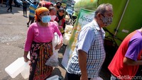 Warga tampak membawa beberapa jerigen atau botol minyak goreng yang kosong saat mengantre minyak goreng murah di kawasan Pasar Kramat Jati.