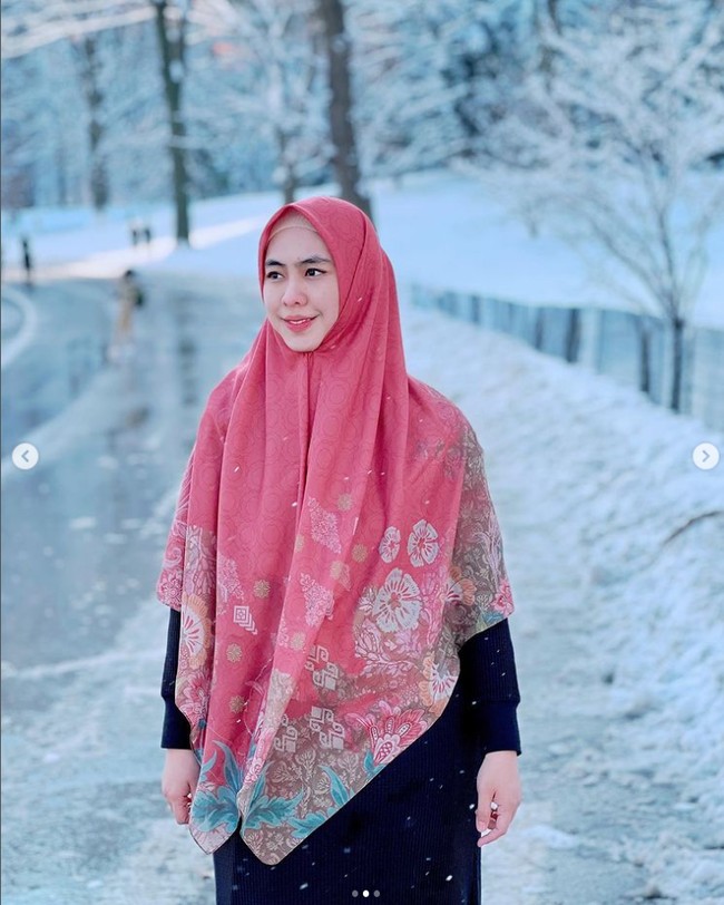 Gaya hijab istri Ory Vitro itu kerap menjadi inspirasi bagi muslimah Tanah Air. Oky menyukai warna pastel dan hijab segi empat motif. Seperti dalam foto ini, ia memakai hijab segi empat motif yang dibiarkan ke depan dan hanya memakai inner dan satu jarum pentul di bawah dagu. Oki memadukan hijab dengan gamis warna hitam. Foto: Dok. Instagram @okisetianadewi.