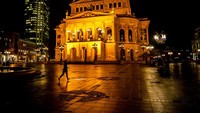 Warga berolahraga di depan Gedung Opera di Frakfurt, Jerman, Selasa (1/2/2022). Kondisi gelap gulita di malam hari mengelilingi cahaya kuning keemasan di gedung yang sudah menua. Seburuk apapun kondisinya, sebaiknya masih menyisakan kemampuan untuk tetap bertahan mencapai kesuksesan dan kemakmuran. (AP Photo/Michael Probst)
