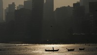 Nelayan mendayung kapal di Mumbai, India, Rabu (2/2/2022). Pantulan cahaya di saat langit mulai gelap memberi harapan dan semangat untuk bisa melalui masa-masa sulit pandemi Covid-19. (AP Photo/Rajanish Kakade)