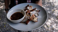 Sepiring berisi daging buaya panggang lengkap dengan saus cocolannya siap disajikan kepada pengunjung.
