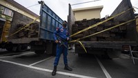 Personel Ditpolairud Polda Sumatera Selatan berjaga didekat barang bukti kayu hasil penebangan hutan secara ilegal (illegal logging) saat ungkap kasus di Palembang, Sumatera Selatan, Kamis (3/2/2022).