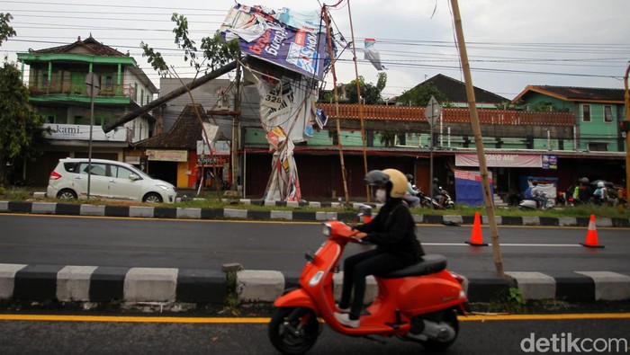 Tiang Listrik dan Papan Reklame Ini Roboh Disapu Angin Kencang Papan reklame, tiang listrik dan travo di Jalan Ringroad Utara, Sleman, Yogyakarta, roboh diterjang angin kenjang. Akibatnya listrik padam.