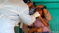 Salah seorang anak-anak dites antigen oleh tenaga kesehatan. 