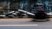Pengguna jalan melintas di Jl Adiaksa Raya, Lebak Bulus, Jakarta Selatan, Jumat (4/2/2022) pukul 15.30 WIB. Di situ, tampak material untuk sumur resapan ditaruh begitu saja di trotoar. Akses pejalan kaki menjadi terganggu.