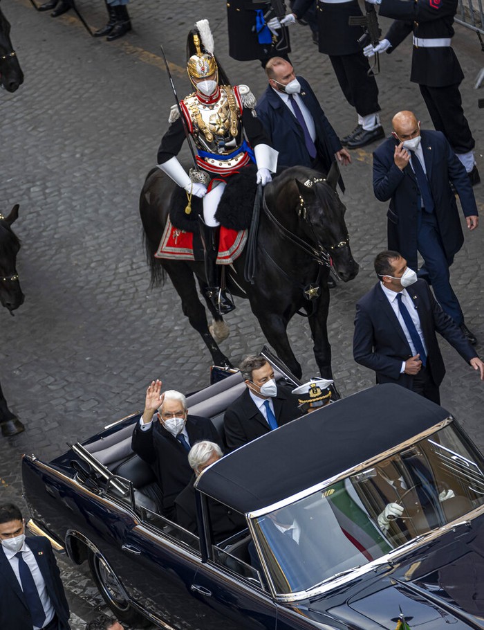 Italian re-elected president Sergio Mattarella sits in his car, left, escorted by mounted Cuirassiers, with Italian Premier Mario Draghi, on their way to the Quirinale Presidential Palace in Rome, for his installation ceremony, Thursday, Feb. 03, 2022. Mattarella was elected on Saturday night to a second seven-year term as the country's head of state, ending days of political impasse by party leaders that risked eroding the nation's credibility. (AP Photo/Domenico Stinellis)
