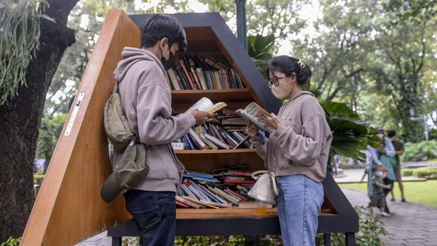Dua orang pengunjung membaca buku di perpustakaan mini Taman Suropati, Jakarta, Sabtu (8/1/2022). Jakarta ditetapkan sebagai 'City of Literature' atau Kota Sastra Dunia dari 49 kota lain di dunia yang tergabung dalam jaringan kota kreatif jaringan kota kreatif dunia atau 'UNESCO's Creative City Network tahun 2021' oleh Badan Pendidikan dan Kebudayaan PBB (UNESCO). ANTARA FOTO/M Risyal Hidayat/rwa.