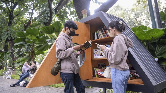 Dua orang pengunjung membaca buku di perpustakaan mini Taman Suropati, Jakarta, Sabtu (8/1/2022). Jakarta ditetapkan sebagai 'City of Literature' atau Kota Sastra Dunia dari 49 kota lain di dunia yang tergabung dalam jaringan kota kreatif jaringan kota kreatif dunia atau 'UNESCO's Creative City Network tahun 2021' oleh Badan Pendidikan dan Kebudayaan PBB (UNESCO). ANTARA FOTO/M Risyal Hidayat/rwa.