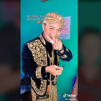 Akun TikTok @irfaaghata menjawab pertanyaan salah satu warganet soal apakah yang memakaikan paes dan sanggul juga pengantin pria. Terima kasih masukannya kak, tapi mohon maaf yang maes nyanggul itu yang pakai jilbab ungu😁, balasnya. Ia juga membalas komentar warganet yang mengatakan jika pasangan pengantin ini irit budget. Lebih tepatnya kalau kita bisa ngapain nggak wkkkk manfaatkan kemampuan kita dong😁, jawab MUA yang tinggal di Wonosobo, Jawa Tengah itu. Foto: Dok. Tangkapan layar akun TikTok @irfaaghata