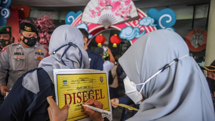 Petugas Satpol PP bersiap untuk menyegel Mal Festival Citylink di Bandung, Jawa Barat, Jumat (4/2/2022). Satuan Tugas COVID-19 Kota Bandung memberikan denda serta menyegel sementara Mal Festival Citylink selama tiga hari imbas dari adanya kerumunan dalam pertunjukan barongsai saat perayaan Tahun Baru Imlek pada Selasa (1/2/2022). ANTARA FOTO/Raisan Al Farisi/tom.