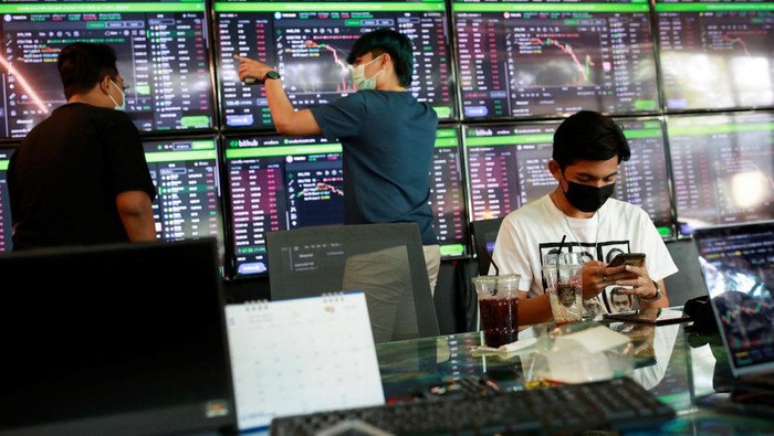 People pass their time at a cafe which has dozens of screens showing the latest trends and prices on various cryptocurrencies for their crypto investors customers in Nakhon Ratchasima, Thailand January 21, 2022. Picture taken January 21, 2022. REUTERS/Soe Zeya Tun