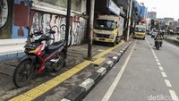 Kendaraan roda empat dan dua terlihat parkir di trotoar kawasan Jatinegara, Jakarta, Sabtu (5/2/2022).