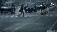 Arus lalu lintas di Bundaran HI terpantau lancar meski hujan deras mengguyur kawasan tersebut.