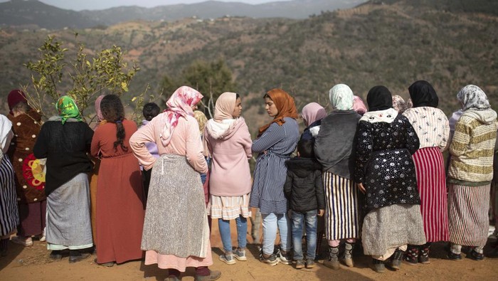 Duka Ortu Rayan dan Antusias Warga Saksikan Evakuasi The parents of 5-year-old Rayan walk toward an ambulance after seeing their son's retrieved body after he fell into a hole and was stuck there for several days, in the village of Ighran in Morocco's Chefchaouen province, Saturday, Feb. 5, 2022. The boy died and was pulled out Saturday night by rescuers after a lengthy operation that captivated global attention. (AP Photo/Mosa'ab Elshamy)