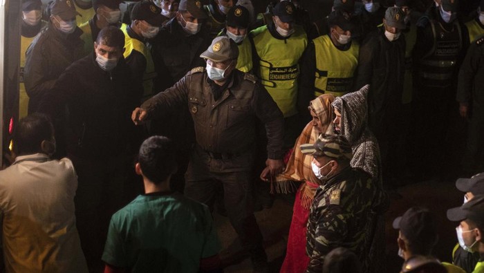 Duka Ortu Rayan dan Antusias Warga Saksikan Evakuasi The parents of 5-year-old Rayan walk toward an ambulance after seeing their son's retrieved body after he fell into a hole and was stuck there for several days, in the village of Ighran in Morocco's Chefchaouen province, Saturday, Feb. 5, 2022. The boy died and was pulled out Saturday night by rescuers after a lengthy operation that captivated global attention. (AP Photo/Mosa'ab Elshamy)