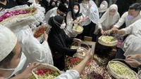 Keluarga almarhum menaburkan bunga di makam.