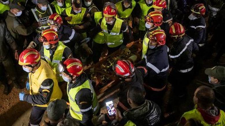 MOROCCO-ACCIDENT Moroccan emergency services teams carry five-year-old Rayan Oram to an ambulance after pulling him from a well shaft he fell into on February 1, in the remote village of Ighrane in the rural northern province of Chefchaouen on February 5, 2022. - Moroccan rescue crews found the five-year-old boy dead at the bottom of a well late on Februay 5, in a tragic end to a painstaking five-day operation that has gripped the nation. (Photo by Fadel SENNA / AFP)