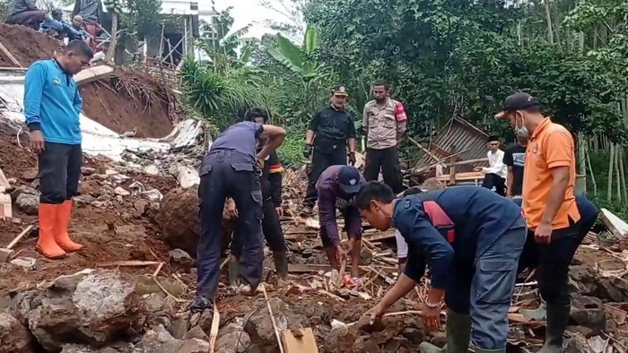 Petugas dan warga melakukan pembersihan puing-puing TPT ambruk di Cianjur
