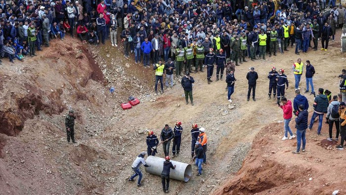 The parents of 5-year-old Rayan walk toward an ambulance after seeing their son's retrieved body after he fell into a hole and was stuck there for several days, in the village of Ighran in Morocco's Chefchaouen province, Saturday, Feb. 5, 2022. The boy died and was pulled out Saturday night by rescuers after a lengthy operation that captivated global attention. (AP Photo/Mosa'ab Elshamy)