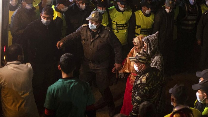 The parents of 5-year-old Rayan walk toward an ambulance after seeing their sons retrieved body after he fell into a hole and was stuck there for several days, in the village of Ighran in Moroccos Chefchaouen province, Saturday, Feb. 5, 2022. The boy died and was pulled out Saturday night by rescuers after a lengthy operation that captivated global attention. (AP Photo/Mosaab Elshamy)