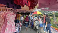 Pedagang kaki lima memanfaatkan kawasan Kanal Banjir Timur (KBT) untuk menggelar lapak meski kasus omicron meningkat.