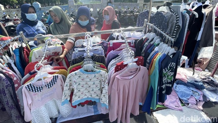 Kasus Covid-19 varian omicron terus naik di Jakarta. Neski demikian warga tetap berolahraga dan berbelanja di PKL yang memenuhi Banjir Kanal Timur (BKT).
