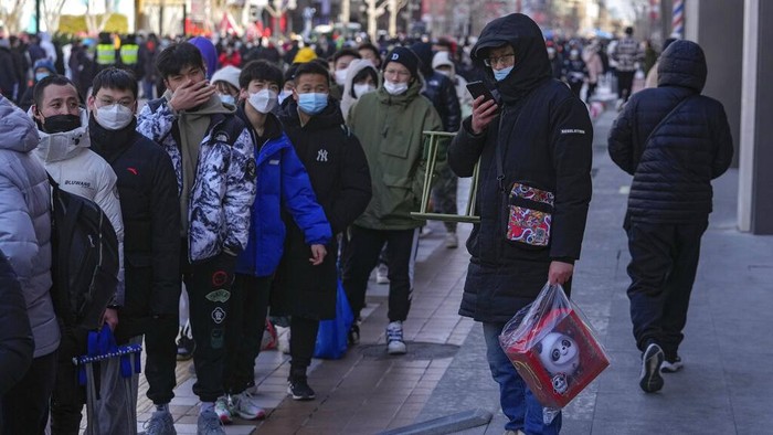 Antrean Panjang Demi Suvenir Olimpiade Beijing yang Langka A man carries a plastic chair as he and hundreds of residents line up to visit a store selling 2022 Winter Olympics memorabilia in Beijing, Monday, Feb. 7, 2022. The race is on to snap up scarce 2022 Winter Olympics souvenirs. Dolls of mascot Bing Dwen Dwen, a panda in a winter coat, sold out after buyers waited in line overnight in freezing weather. (AP Photo/Andy Wong)