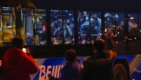Atlet asing di dalam bus menanggapi warga di jalan saat mereka menuju ke Stadion Nasional menjelang upacara pembukaan Olimpiade Musim Dingin 2022, di Beijing, (4/2/2022). Loop tertutup adalah bagian dari protokol COVID ketat yang diberlakukan oleh negara tempat virus corona pertama kali muncul tetapi mengklaim beberapa tingkat kematian dan infeksi terendah di dunia. (AP Photo/Andy Wong)