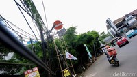 Kabel-kabel di dekat tiang juga tampak menjuntai dan berjarak sekitar 160 cm dari trotoar sehingga bisa menyentuh kepala warga. 