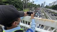 Sementara lalu lintas di tol sekitarnya nampak ramai lancar.