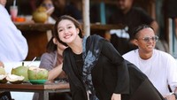 Berlibur ke pantai, Chika ikut memesan beberapa buah kelapa untuk menghilangkan dahaga. Mengenakan pakaian hitam dan kerudung penutup kepala, Chika tampak bahagia bisa melepaskan penatnya. Foto: Instagram/chandrika_