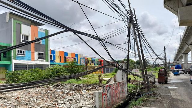 Kabel semrawut dan tiang miring di Jl Raya Bekasi, Cakung, Jakarta Timur, Senin (7/2/2022).