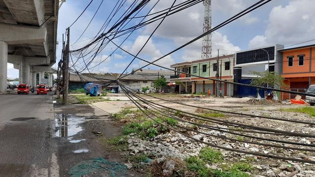 Kabel semrawut dan tiang miring di Jl Raya Bekasi, Cakung, Jakarta Timur, Senin (7/2/2022).