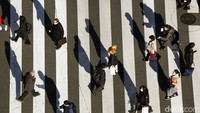 Hitam putih perlintasan zebracross dipenuhi bayangan panjang pekerja pulang kantor di Tokyo, Jepang, Senin (31/1/2022).  Rutinitas kerja membuat penjara modern yang bagi sebagian orang membosankan. (AP Photo/Eugene Hoshiko)