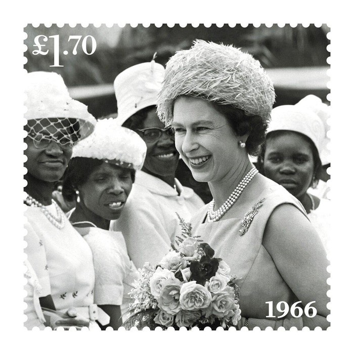 This undated handout provided by Royal Mail on Friday, Feb. 4, 2022 shows of one of eight new stamps showing Queen Elizabeth II smiling, wearing a burgundy outfit and hat, during a visit to the MI5 headquarters in February 2020, which has been issued to mark the monarch's Platinum Jubilee. (Royal Mail via AP)