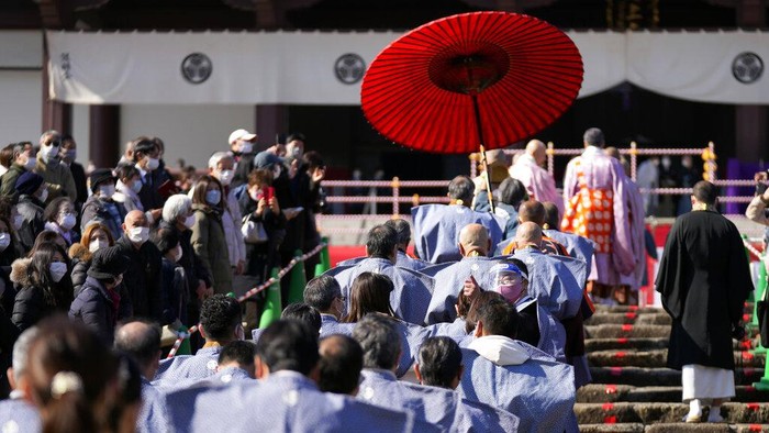 Ritual Melempar Kacang, Berharap Keberuntungan People try to catch lucky beans scattered by celebrities during the