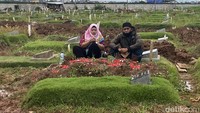 Dua orang warga memanjatkan doa untuk anggota keluarganya yang dimakamkan di TPU Rorotan, Jakarta.