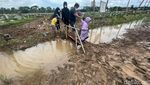 Saat Warga Nyeker Lewati Tanah Becek Demi Berziarah di TPU Rorotan