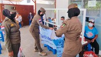 Petugas Pol PP yang tergabung dalam Satgas COVID-19 Banyuwangi melakukan penertiban banner pos rapid antigen di Ketapang, Banyuwangi, Jawa Timur, Senin (7/2/2022).