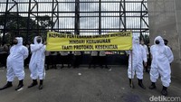 Tampak sejumlah polisi berjaga di depan pagar Gedung DPR RI. Spanduk bertuliskan imbauan untuk menghindari kerumunan di tengah merebaknya varian Omicron juga terlihat di tengah aksi unjuk rasa tersebut.