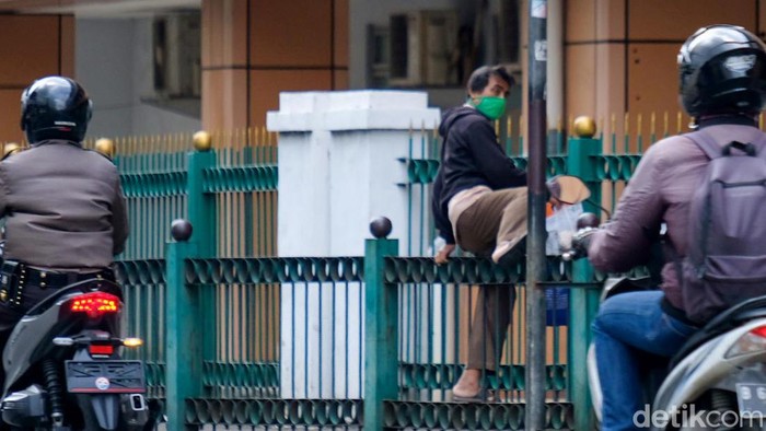 Sejumlah warga masih kedapatan panjat pagar saat masuk-keluar dari Stasiun Cikini, Jakarta. Mereka cari jalan pintas karena akses keluar masuk yang dinilai jauh