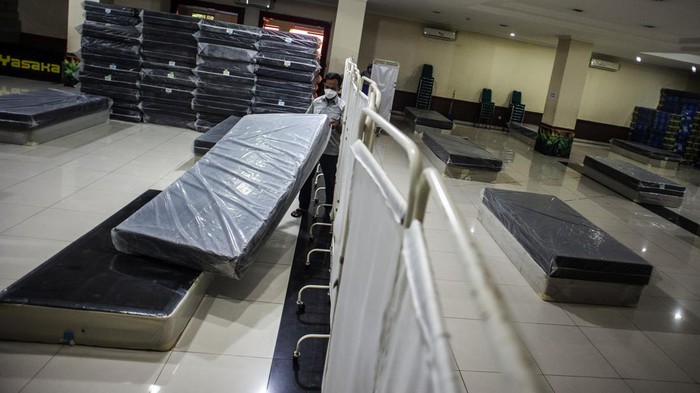 Petugas menata tempat tidur di GOR Kecamatan Tanjung Priok, Jakarta, Selasa (8/2/2022). Pemerintah Kota Jakarta Utara menyiapkan Gelanggang Olahraga (GOR) Tanjung Priok sebagai lokasi isolasi untuk penanganan pasien COVID-19 dengan kapasitas mencapai 400 tempat tidur. ANTARA FOTO/Aprillio Akbar/wsj.